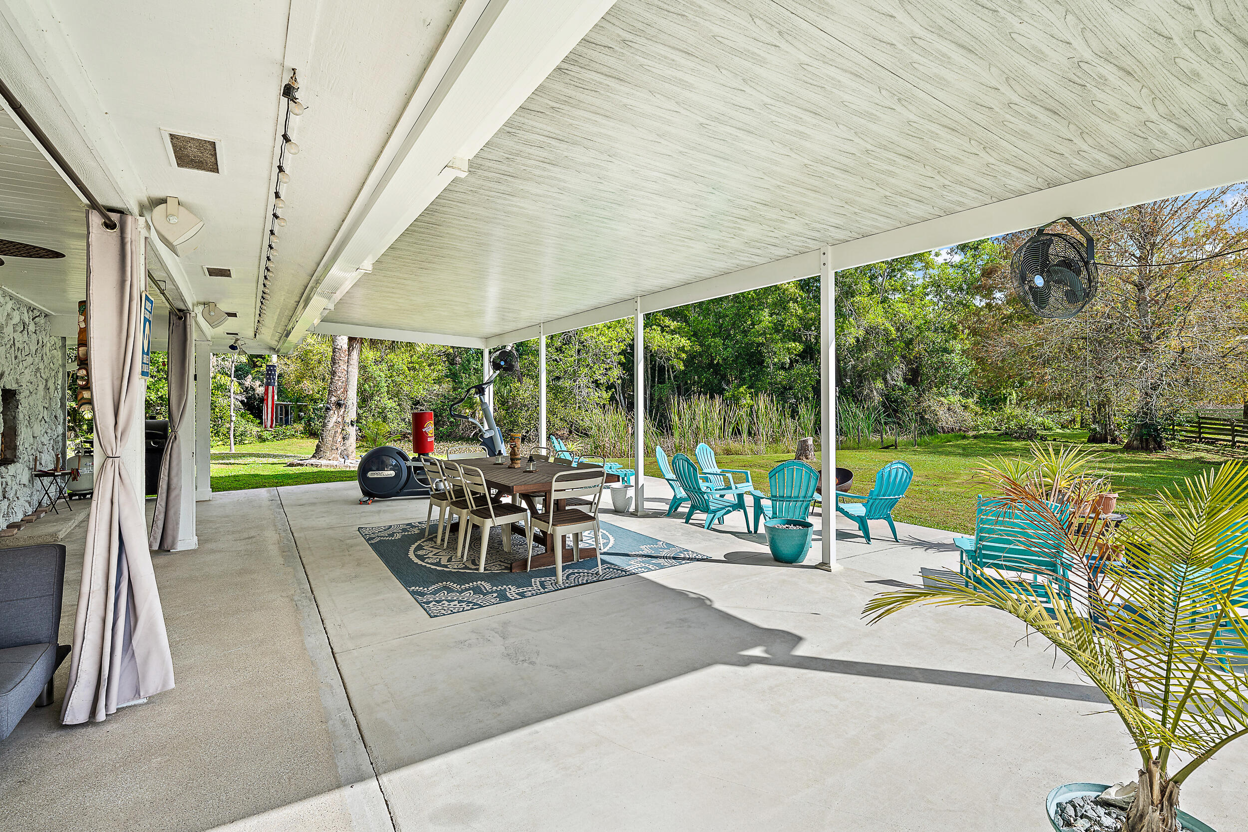 17696 Winterhawk Trail Jupiter, FL 33478 - Photo 16 of 21 a view of a patio with a dining table and chairs under an umbrella