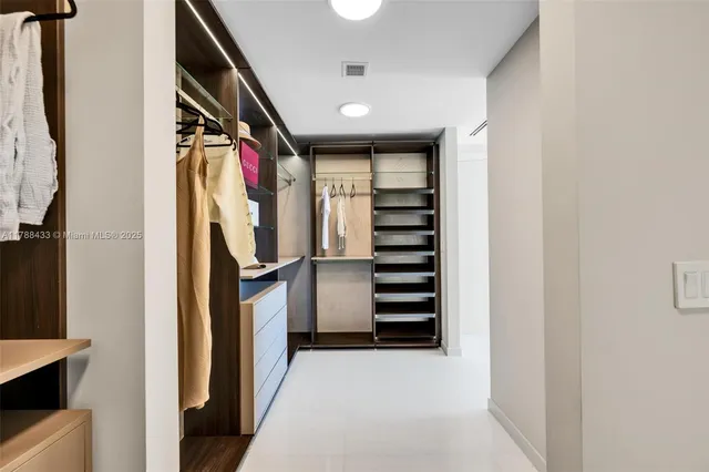 a large white bathroom with a tub a sink and mirrors