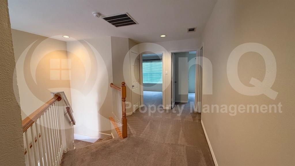 18240 Midway Road, Unit 1204 Dallas, TX 75287 - Photo 17 of 27 Carpeted hallway featuring multiple doorways, recessed lighting, and a natural wood and white baluster staircase