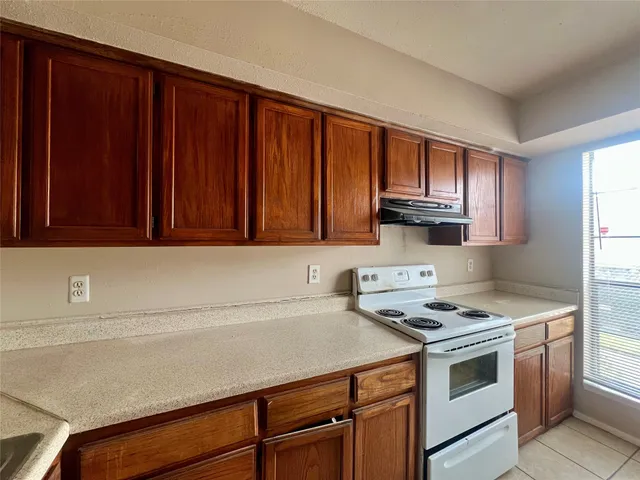 a kitchen with wooden cabinets and a stove top oven