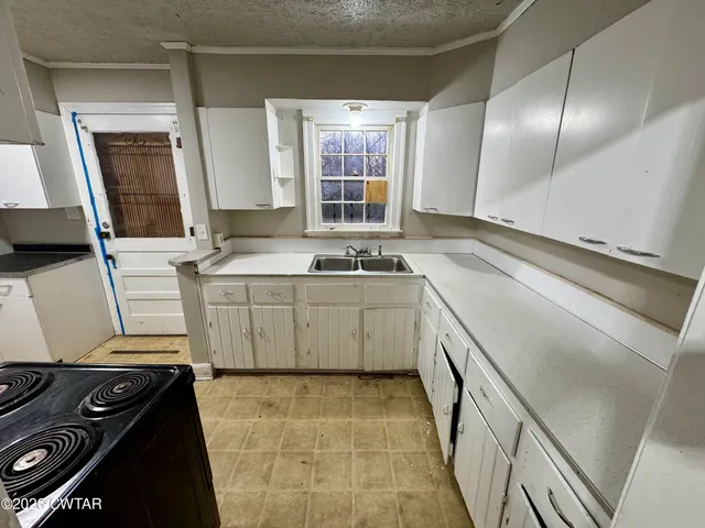 a kitchen with a sink stove and cabinets