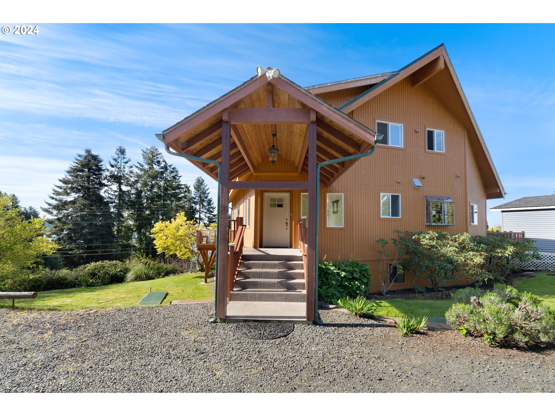 66599 Quail Road North Bend, OR 97459 - Photo 38 of 45 a front view of a house with a garden and plants