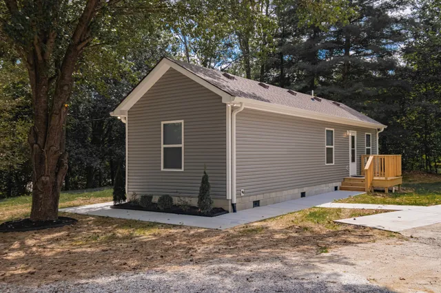 a view of a house with backyard and trees