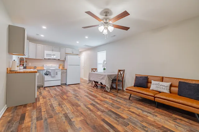 a living room with stainless steel appliances kitchen island granite countertop furniture and a couch