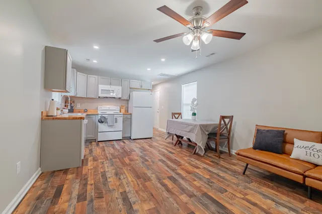 an empty room with wooden floor and ceiling fan
