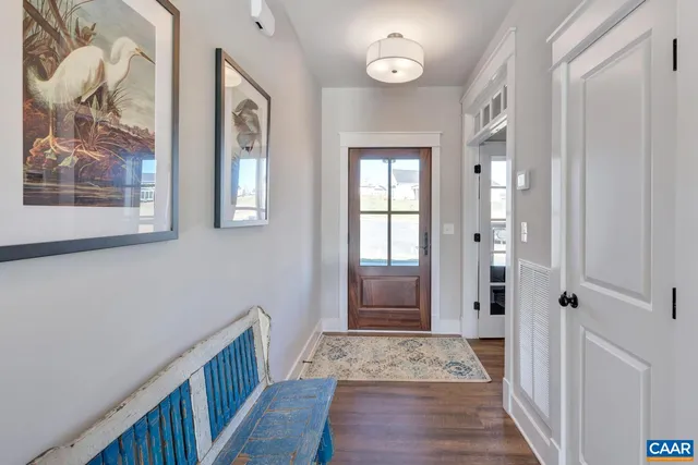 a view of a hallway with wooden floor and a bathroom