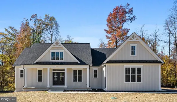 a front view of a house with a tree