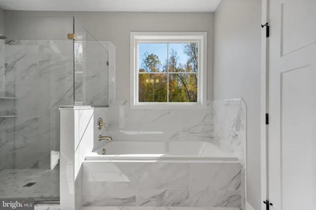 a white bath tub sitting next to a shower