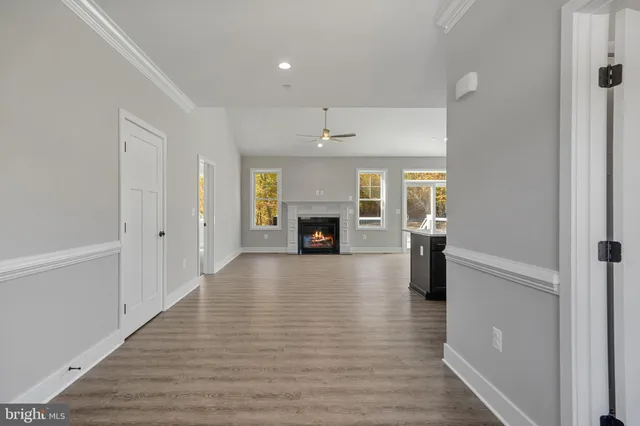 a view of a livingroom with wooden floor a fireplace and entryway