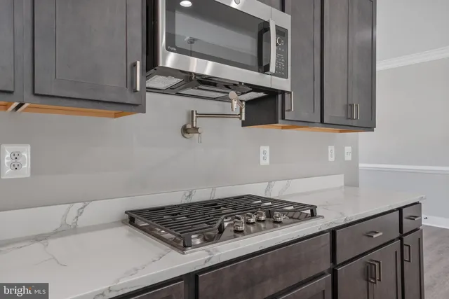 a kitchen with stainless steel appliances granite countertop a stove and a microwave