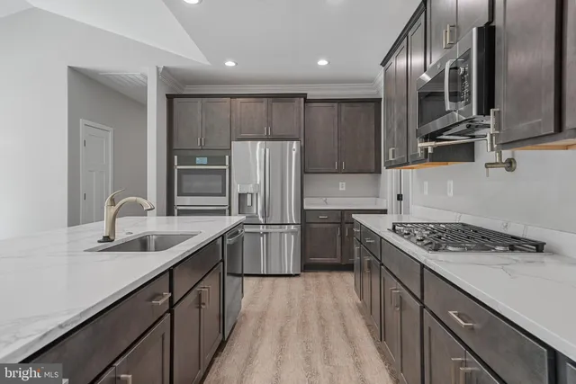 a kitchen with stainless steel appliances granite countertop a sink stove and refrigerator