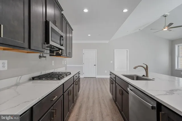 a kitchen with stainless steel appliances granite countertop a sink stove and cabinets