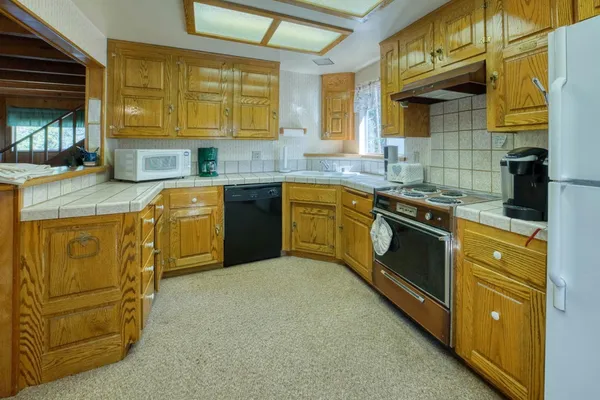 a kitchen with stainless steel appliances granite countertop sink stove and cabinets