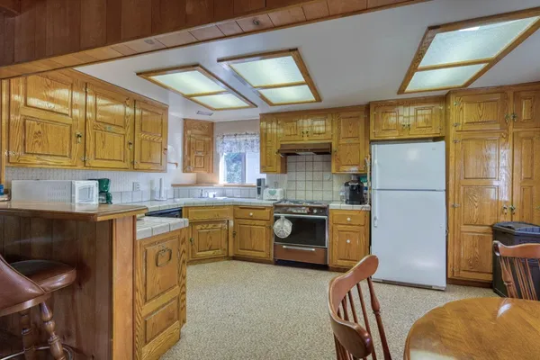 a kitchen with a refrigerator and a stove top oven