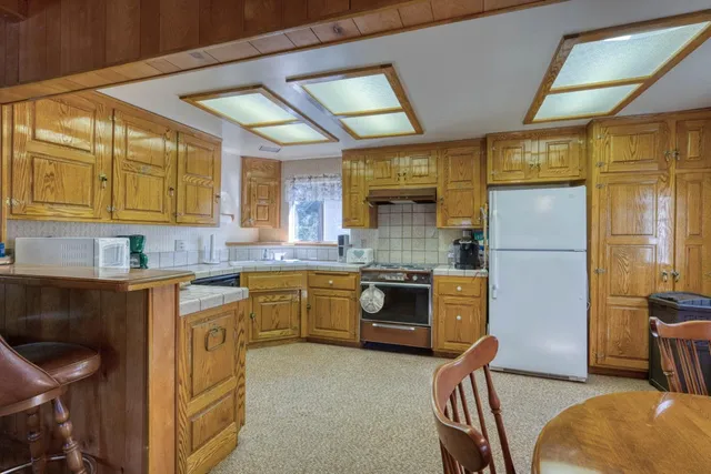 a kitchen with a refrigerator and a stove top oven