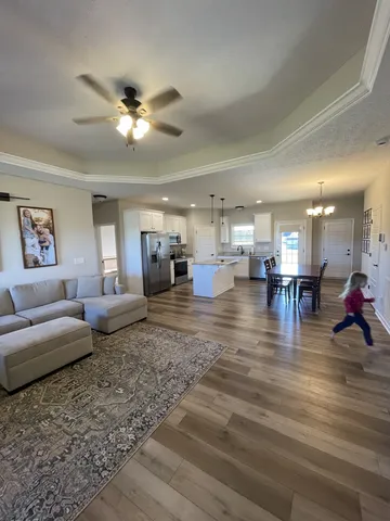 a living room with lots of furniture and view of kitchen
