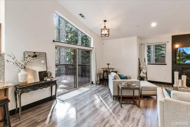 a living room with furniture a flat screen tv and a large window