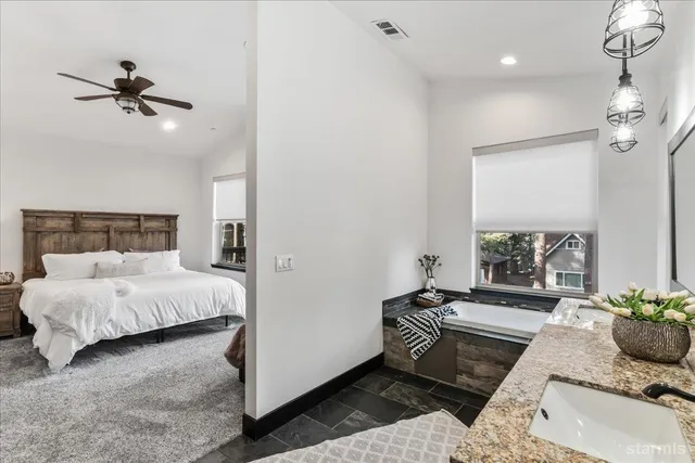 a bedroom with a bed a couch and a chandelier