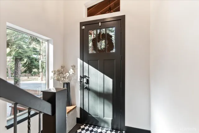 a view of a hallway with wooden floor and stairs