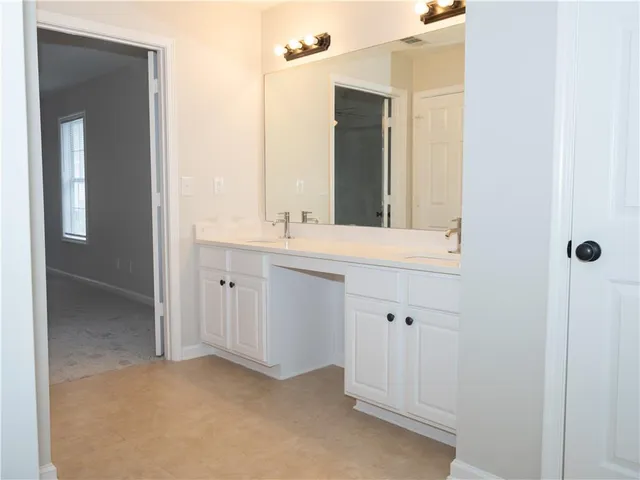 a bathroom with a double vanity sink and mirror