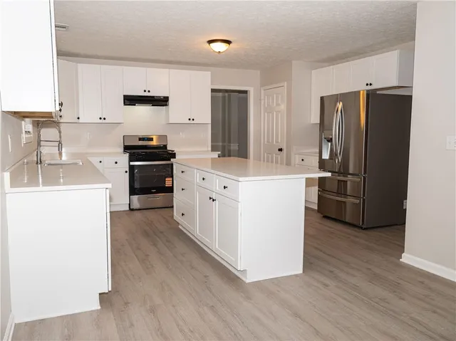 a kitchen with white cabinets and stainless steel appliances