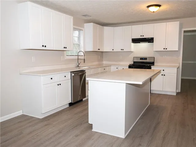 a kitchen with a sink cabinets and wooden floor