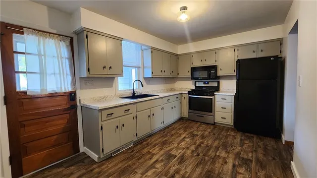 a kitchen with granite countertop a refrigerator stove and sink