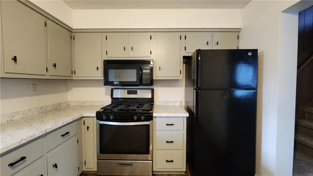 a kitchen with stainless steel appliances a refrigerator stove and microwave