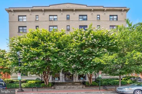 a front view of a building with trees