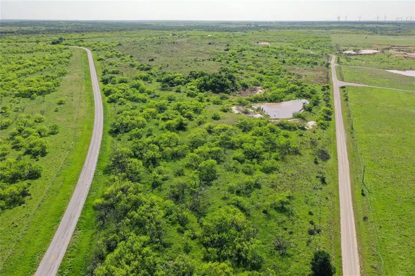 a view of a green field with an ocean view