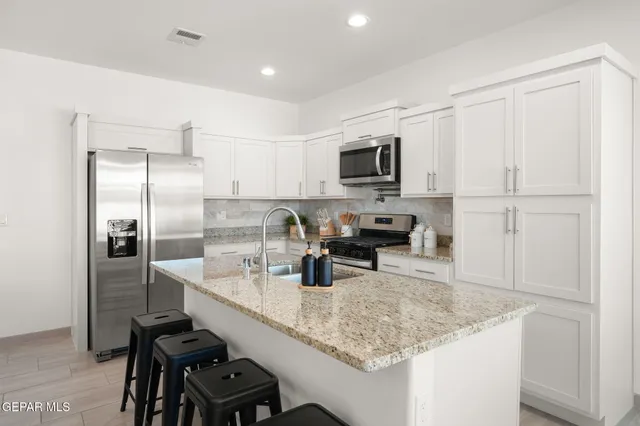 a kitchen with kitchen island a counter top space appliances and cabinets
