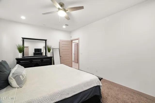 a bedroom with a large bed and a chandelier