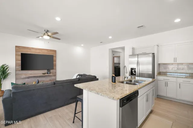 a kitchen with a stove and a flat screen tv