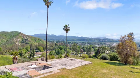 an aerial view of residential house with outdoor space and trees all around