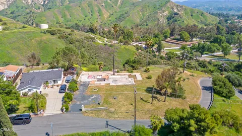 an aerial view of residential houses with outdoor space and trees