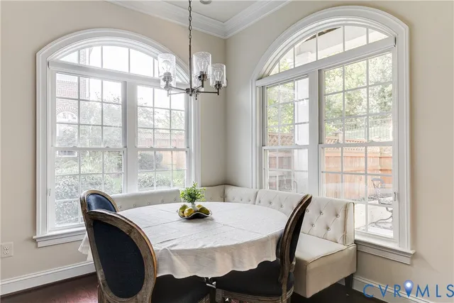 a view of a dining room with furniture a chandelier and wooden floor