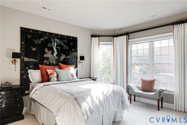 a bedroom with a bed and a large window