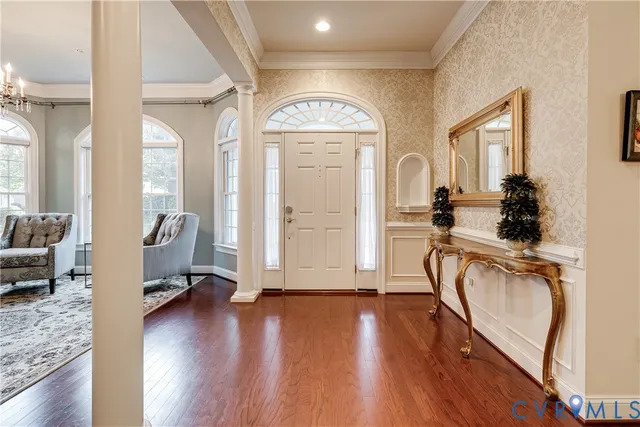 a view of a livingroom with furniture hardwood floor a ceiling fan and windows