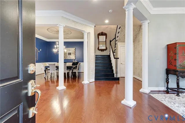 a view of a dining room with furniture a chandelier and wooden floor