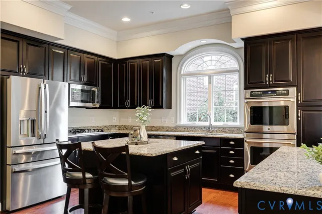 a kitchen with stainless steel appliances a stove a sink and a refrigerator