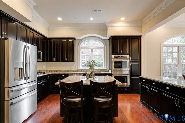 a kitchen with stainless steel appliances granite countertop a sink stove and refrigerator