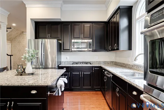 a kitchen with granite countertop a sink dishwasher a stove and a refrigerator with wooden cabinets