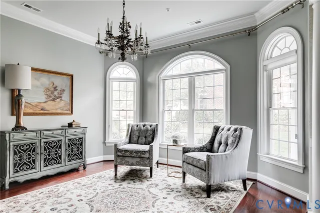 a view of a dining room with furniture a chandelier and wooden floor