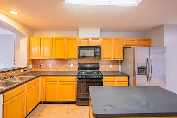 a kitchen with stainless steel appliances granite countertop a sink and a stove
