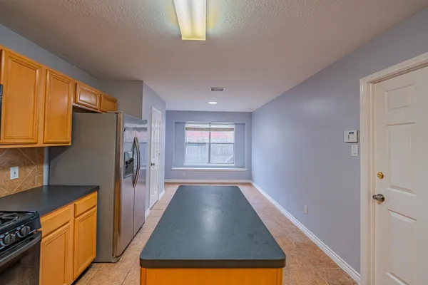 a view of a kitchen with wooden floor and a window