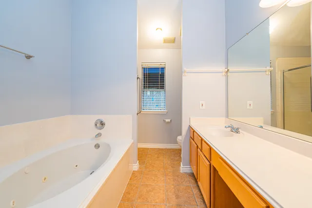 a bathroom with a tub sink and mirror