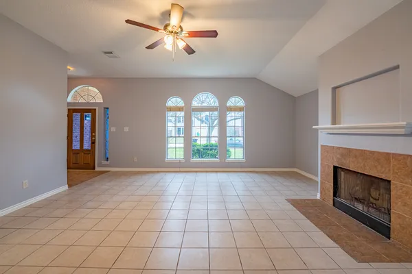 a view of an empty room with window and fire place