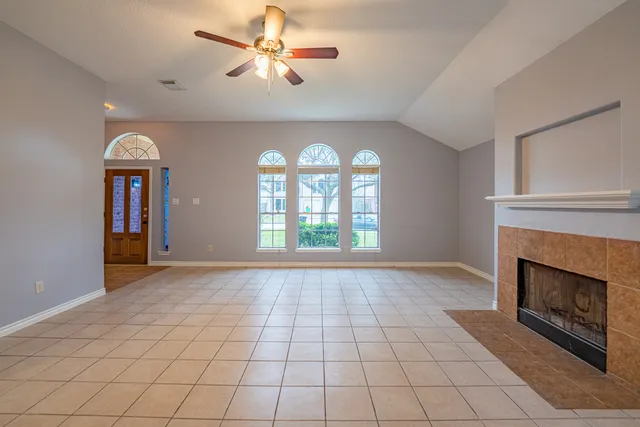 a view of an empty room with window and fire place