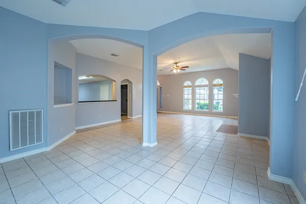 a view of a hallway with wooden floor and a living room