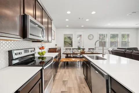 a kitchen with stainless steel appliances granite countertop sink stove top oven and cabinets